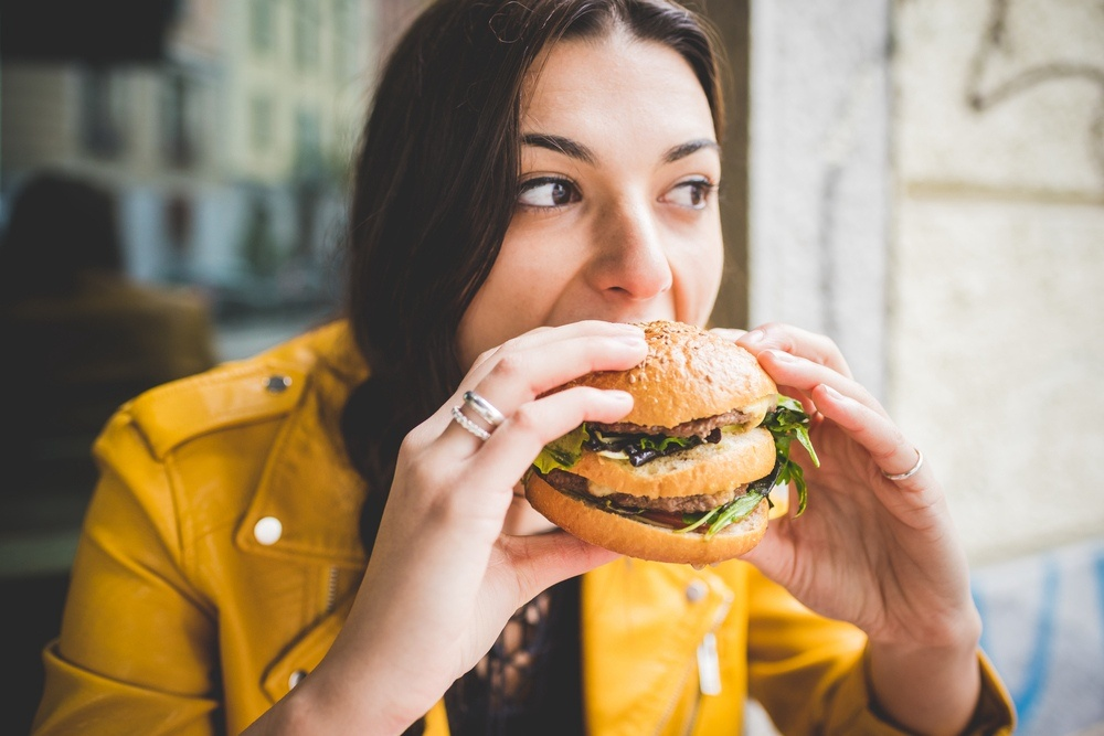 женщина ест гамбургер