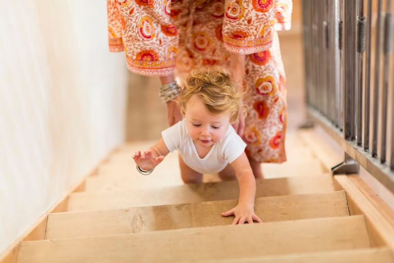 мать помогает ребенку подняться по лестнице