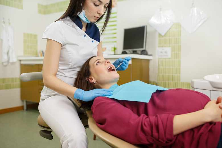Беременная женщина во время стоматологического обследования